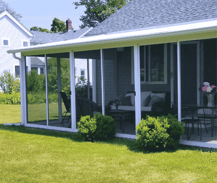 White screen room addition with wraparound screened panels attached to a traditional home overlooking a grassy yard.