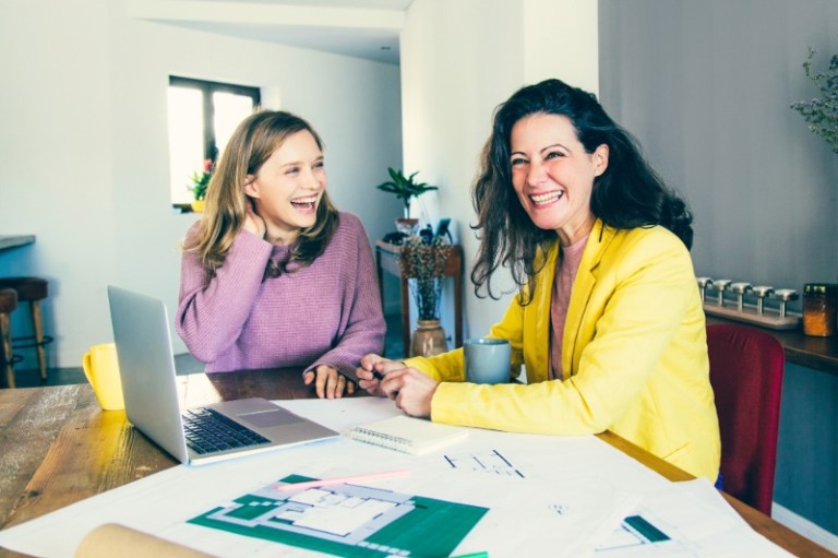 A happy woman meets with a designer at her home about an improvement project.