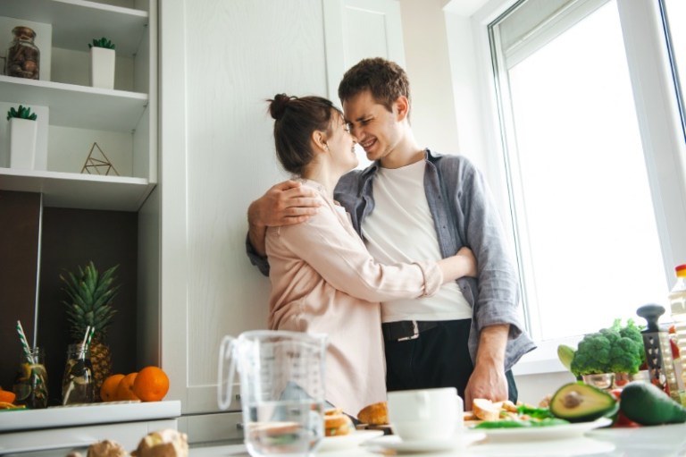 A happy couple embraces as they enjoy their home.