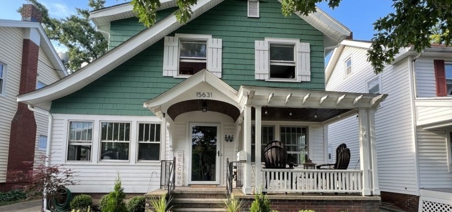 Craftsman-inspired green and white home in Charlotte featuring a covered porch and welcoming curb appeal—showcasing custom exterior updates for Southern charm and functionality.