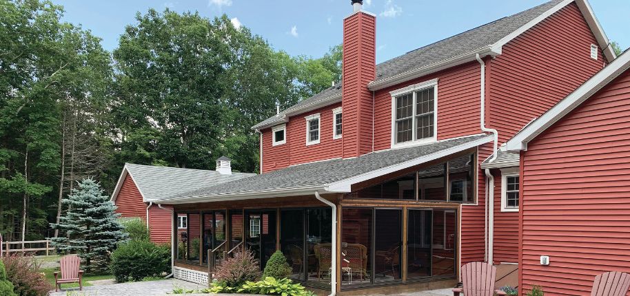 Classic red siding home with a cozy screened porch and backyard patio, showcasing Great Day Improvements’ craftsmanship in Avon, Ohio.