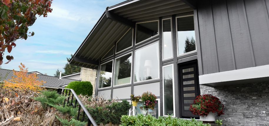 Elegant gray craftsman-style home with large windows and lush landscaping, highlighting Great Day Improvements’ exterior renovation in Centennial, Colorado.