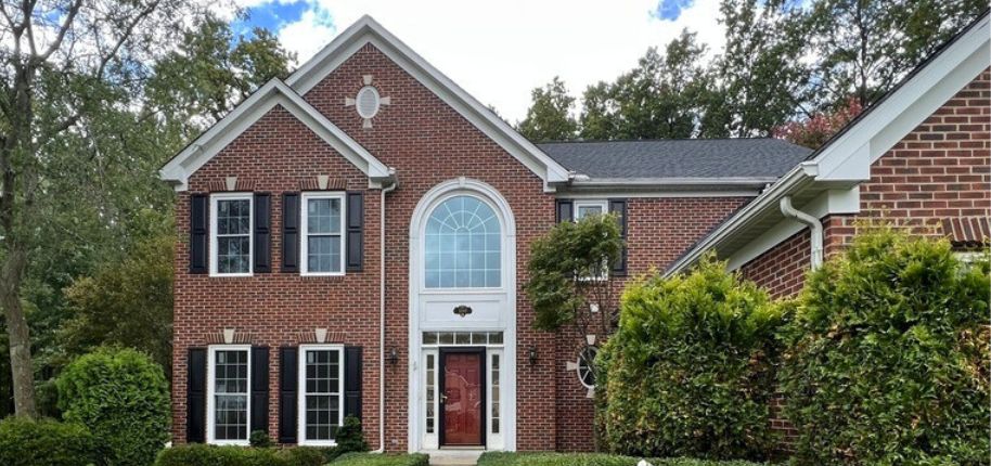 Stately two-story brick home in Chicago with arched windows and classic black shutters—exemplifying long-lasting quality and energy-efficient design in urban suburbs.