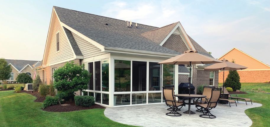 Indianapolis home with enclosed sunroom, brick siding, and patio space—designed for year-round comfort and energy-efficient indoor-outdoor living.