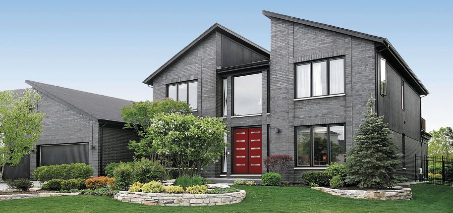 Luxury exterior renovation in Kent showcasing black brickwork and statement entry door.