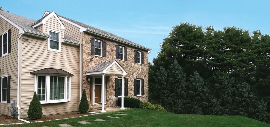 Exterior home remodeling in Smithfield showcasing stonework and updated siding by Great Day Improvements.