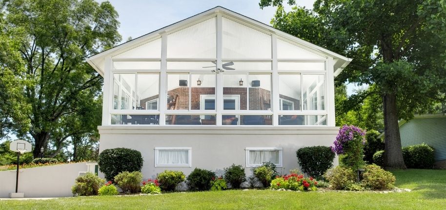 Outdoor living renovation by Great Day Improvements featuring a covered deck, railing system, and landscaped backyard retreat.