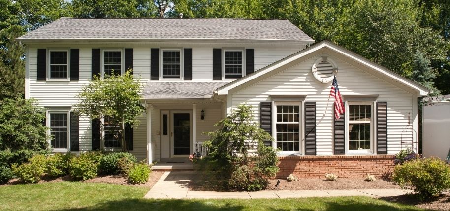 Traditional two-story home with updated siding, replacement windows, and refreshed exterior details, remodeled by Great Day Improvements for improved energy efficiency and timeless style.