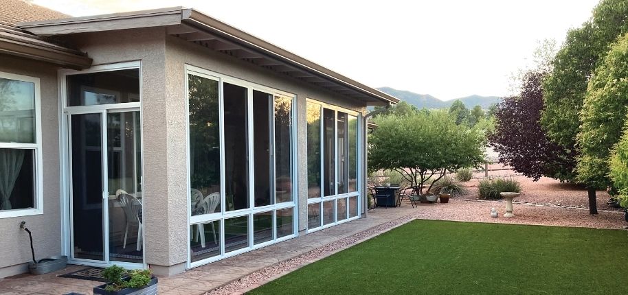 Southwest-style home with a full-length screened enclosure, remodeled by Great Day Improvements to extend outdoor living while maintaining comfort and protection from the elements.