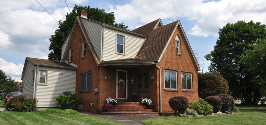 Brick home with updated siding accents and energy-efficient replacement windows, remodeled by Great Day Improvements to boost curb appeal, comfort, and long-term value.