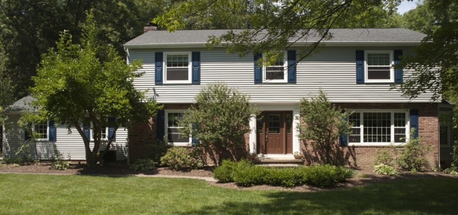 Traditional two-story home with updated siding, shutters, and energy-efficient windows, remodeled by Great Day Improvements to refresh curb appeal and long-term performance.