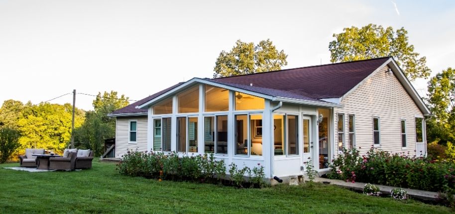 Single-story home with a bright sunroom addition and expansive windows, remodeled by Great Day Improvements to bring in natural light and create a welcoming, functional living space.