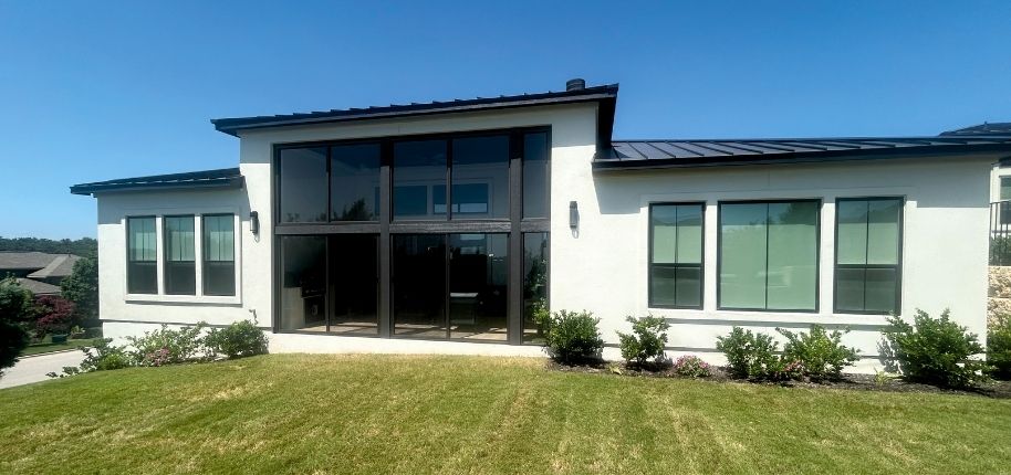 Modern home exterior with a custom glass sunroom addition and expansive windows, remodeled by Great Day Improvements to create seamless indoor-outdoor living.