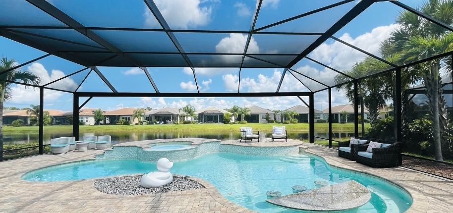 Backyard pool with a full screened enclosure and patio seating, remodeled by Great Day Improvements to provide protected outdoor living and resort-style comfort.