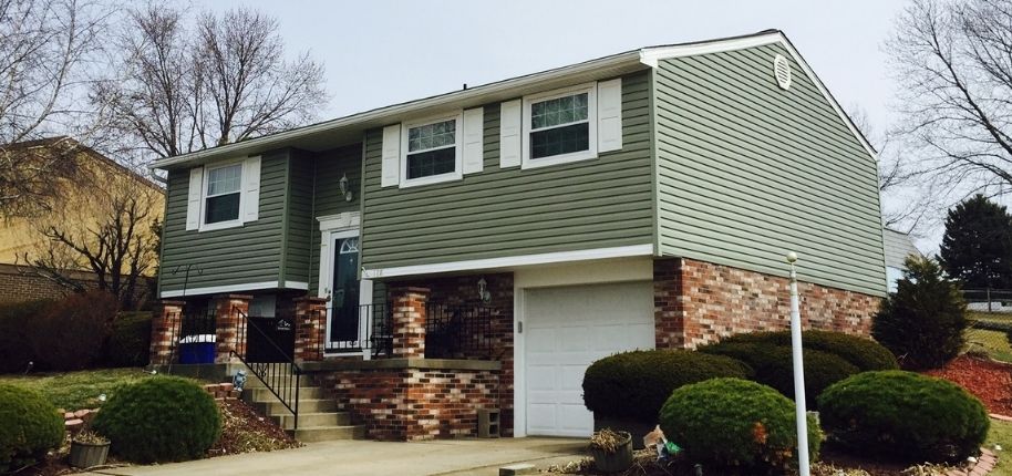 Two-story split-level home with updated siding, brick accents, and energy-efficient windows, remodeled by Great Day Improvements to improve curb appeal, durability, and everyday comfort.
