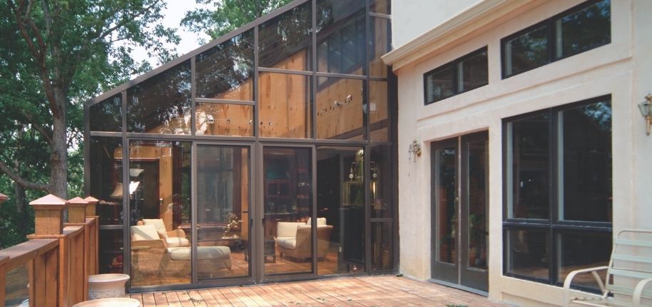 Luxury home with a large screened enclosure featuring floor-to-ceiling panels, remodeled by Great Day Improvements to create a protected, light-filled outdoor retreat.