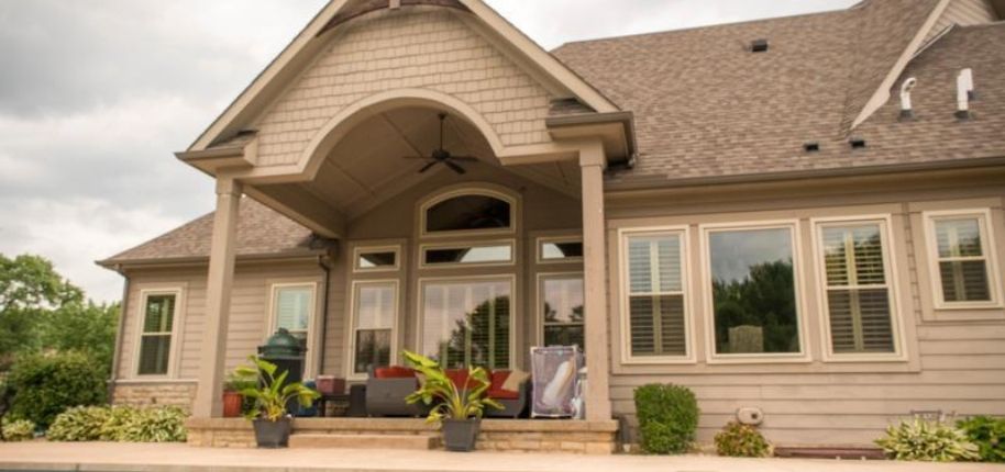 Home exterior with a covered patio and arched roofline, remodeled by Great Day Improvements to enhance outdoor comfort and architectural appeal.