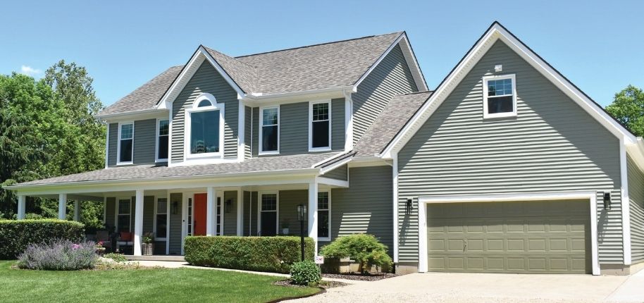 Two-story home with refreshed siding, updated windows, and an attached garage, remodeled by Great Day Improvements to improve energy efficiency, style, and overall value.