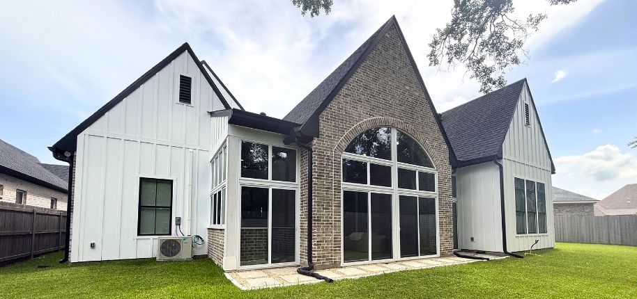 Modern farmhouse-style home with brick accents and large arched windows, remodeled by Great Day Improvements to add natural light, style, and long-term value.
