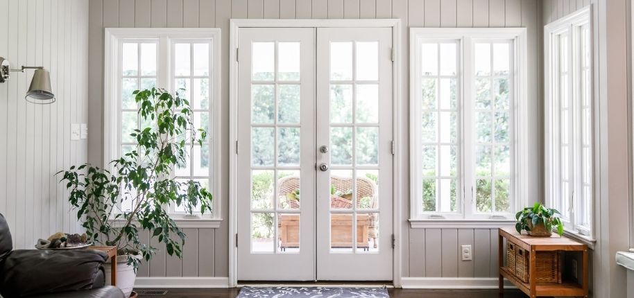 Bright interior space with French doors and tall windows, remodeled by Great Day Improvements to increase natural light, energy efficiency, and indoor-outdoor flow.