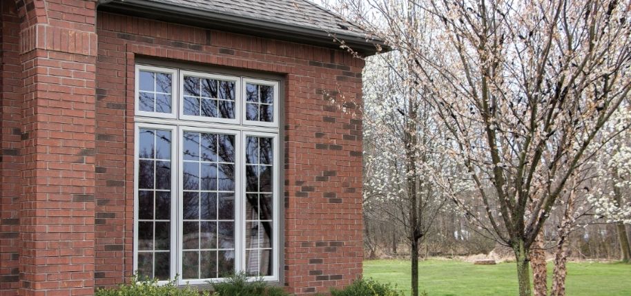 Brick home with large replacement windows and updated exterior details, remodeled by Great Day Improvements to improve energy efficiency and timeless curb appeal.