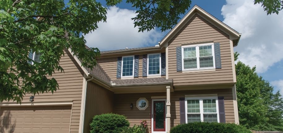 Two-story home with refreshed siding, replacement windows, and updated exterior finishes, remodeled by Great Day Improvements to improve comfort, efficiency, and curb appeal.