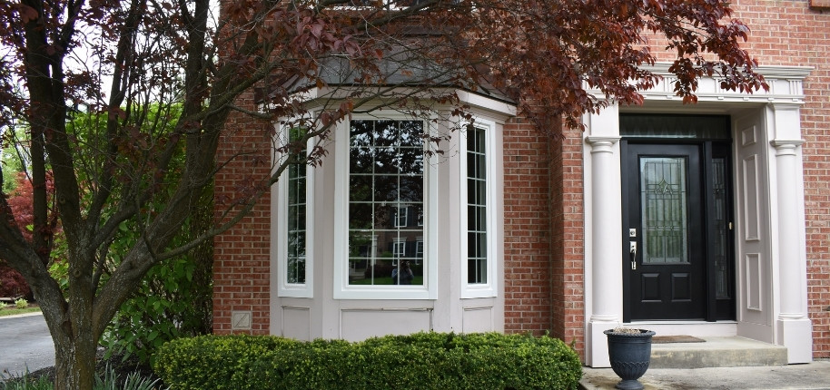Brick home with new front entry door and bay window installation, renovated by Great Day Improvements to enhance security, efficiency, and curb appeal.