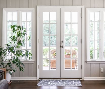 Great Day Improvements installed these white French patio doors with sidelights to create a bright, energy-efficient connection to the outdoor space.