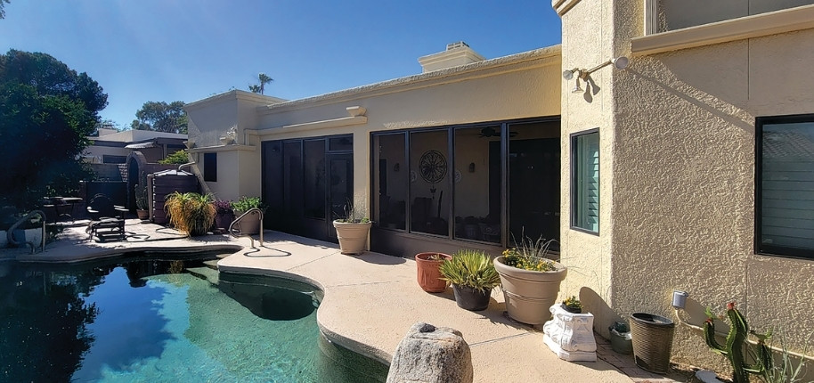 Desert-style stucco home with upgraded sliding glass doors and backyard pool patio, renovated by Great Day Improvements to enhance indoor-outdoor living.