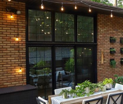 Great Day Improvements completed this custom sliding patio door replacement featuring black grid glass and an oversized transom window above.