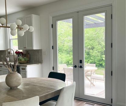 These black-hardware French patio doors were installed by Great Day Improvements to bring elegant functionality to this kitchen dining space.