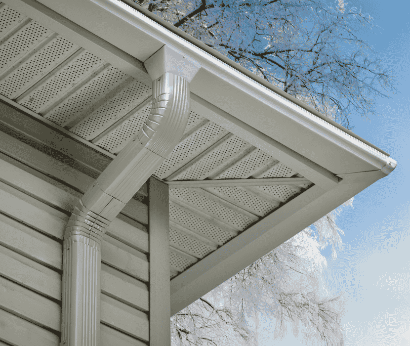 The underside of a white Leafguard gutter system on the roof of a house.