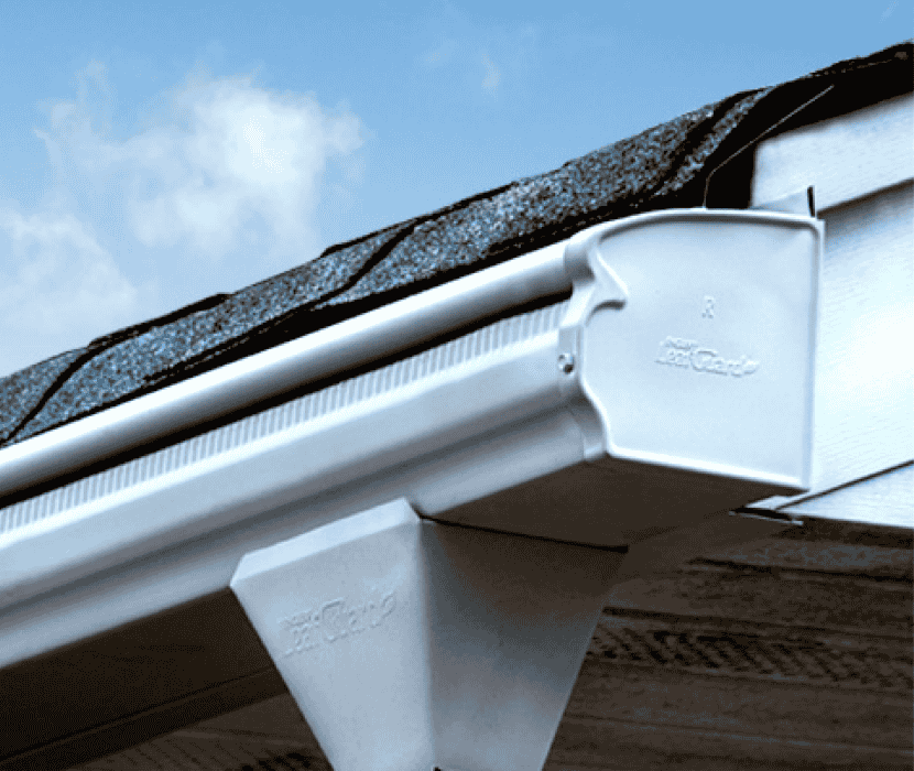 White Leafguard gutter system expertly installed on a house roof.