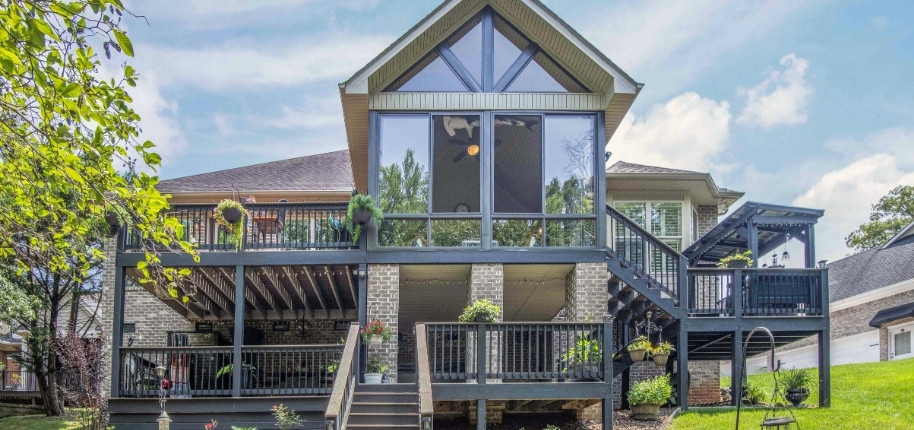 Elevated deck and screened sunroom addition with expansive windows, renovated by Great Day Improvements to expand functional outdoor living.