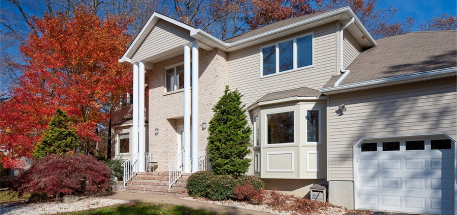 Two-story home with new vinyl siding, updated windows, and modernized exterior finishes, renovated by Great Day Improvements for long-lasting performance.