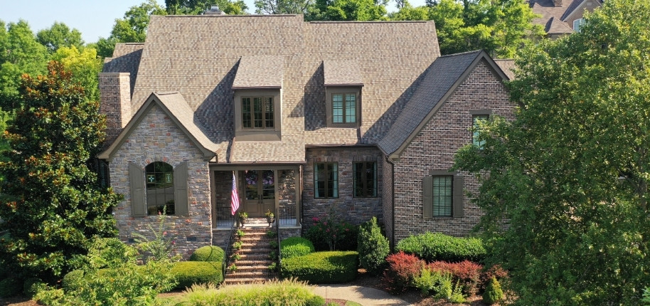 Large brick home with upgraded architectural shingle roof and refreshed exterior finishes, renovated by Great Day Improvements for long-term protection and performance.