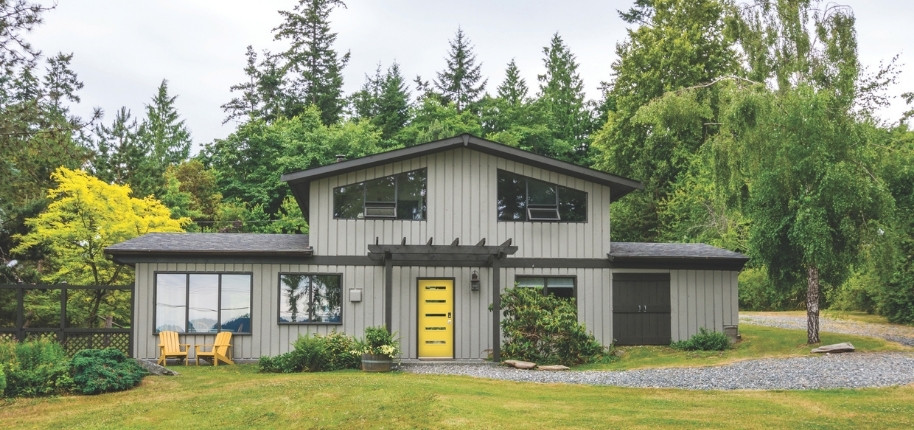 Modern farmhouse exterior with new siding and bold yellow front door, renovated by Great Day Improvements to refresh style and improve energy efficiency.