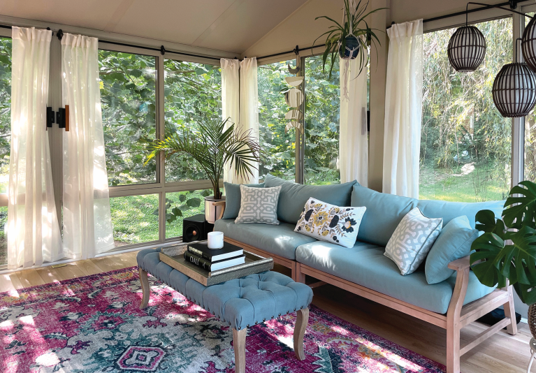 An eclectic sunroom that overlooks a tree-filled backyard.