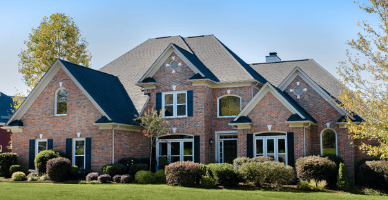 An exterior shot of a red brick home with window replacement completed by Apex Energy Solutions.