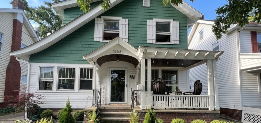 A teal home with white trim and an asymmetrical sloping roof.