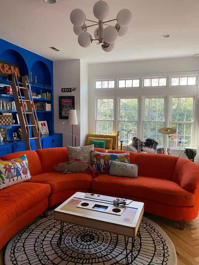 A unique and boldly colored living room, brightly lit by multiple windows.